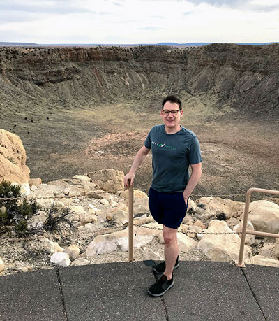 Author Wayne McGraw standing in front of the Barringer Crater in Arizona.
