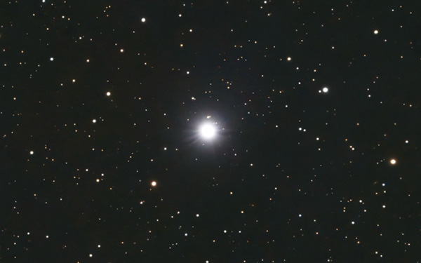 Shows brights star Algol in front a field of stars