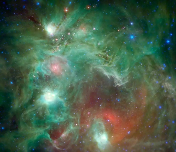 Color photograph showing young stars in dust and gas clouds as part of the Monkey Head Nebula.