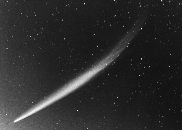 Photo of Comet Ikeya Seki in 1965. Black and white photo showing the comet's tail spread across the sky.
